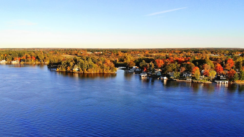 The aerial view of the residential area and waterfront homes surrounded by colorful fall foliage near Wellesley Island, New York, U.S.A