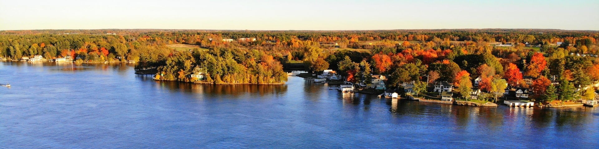 The aerial view of the residential area and waterfront homes surrounded by colorful fall foliage near Wellesley Island, New York, U.S.A