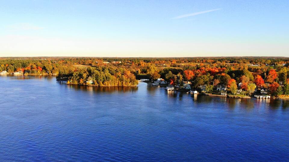 The aerial view of the residential area and waterfront homes surrounded by colorful fall foliage near Wellesley Island, New York, U.S.A