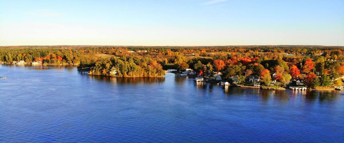 The aerial view of the residential area and waterfront homes surrounded by colorful fall foliage near Wellesley Island, New York, U.S.A