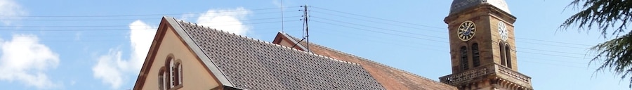 A church with a tiled roof and a clock tower.