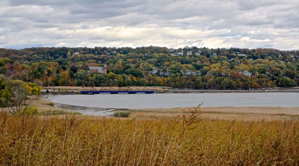 Westchester, NY, USA: A rail bridge spans an inlet on the Hudson River, with St. Augustine’s Roman Catholic Church, Ossining, NY, in the background.