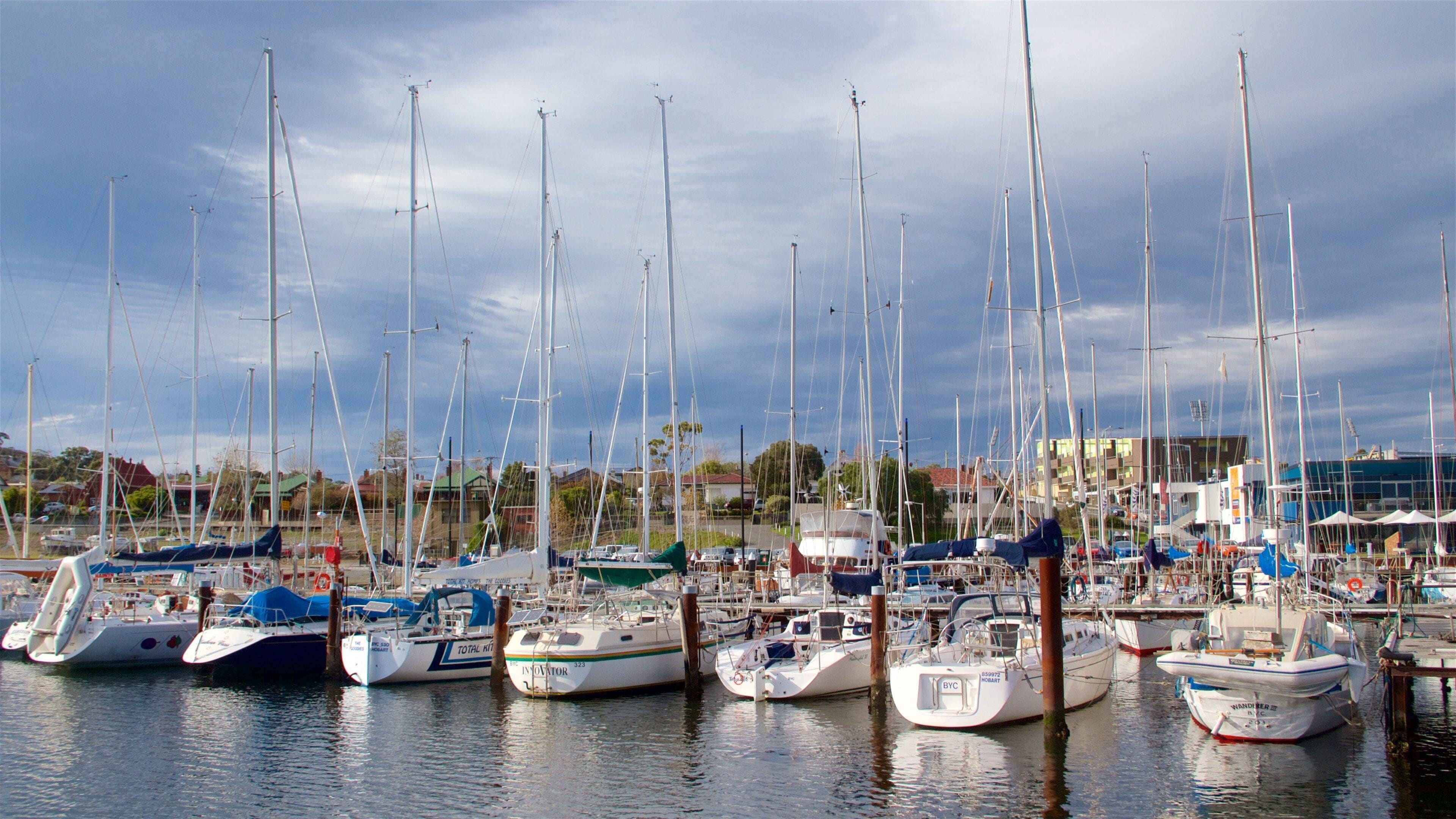 A marina with multiple sailboats docked.