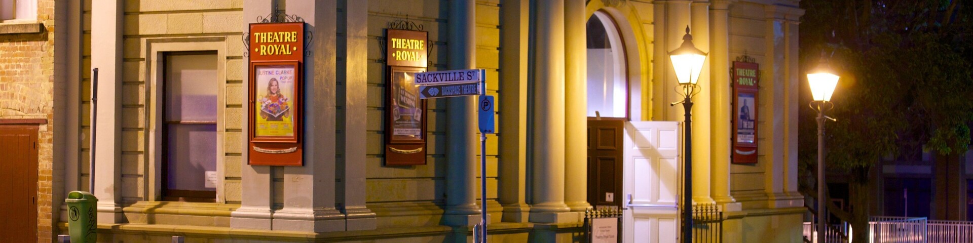 Un edificio histórico de teatro con arquitectura clásica, que incluye columnas y un frontón, y carteles que indican su nombre y ubicación.