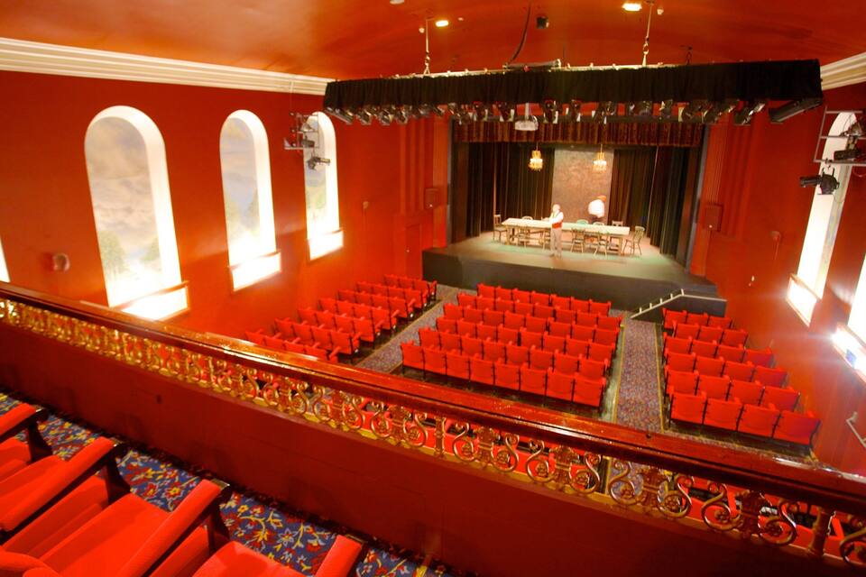 Un teatre amb seients vermells i un escenari.