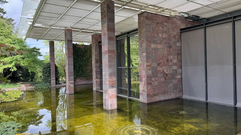 A covered outdoor area with a water feature, stone pillars, and a glass door.