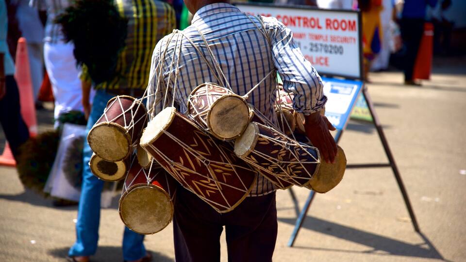 A person carrying multiple drums.