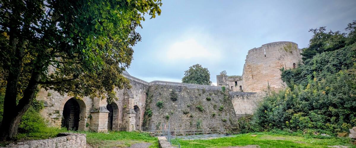 A historic stone wall with arches and a moat.