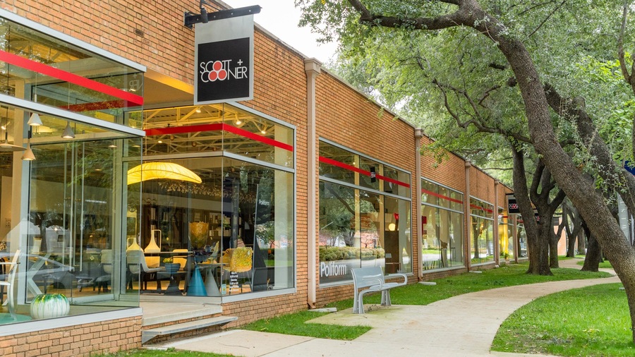 A storefront with a glass facade, a red awning, and a sign that reads "Scott + Cooner."