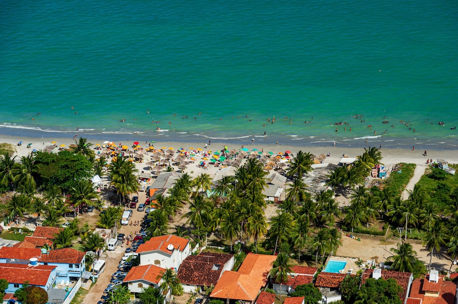 Maria Farinha beach, Olinda, near Recife, Pernambuco State, Brazil on November 15, 2012. Aerial view of the beach with colorful parasols and countless people on the beach.