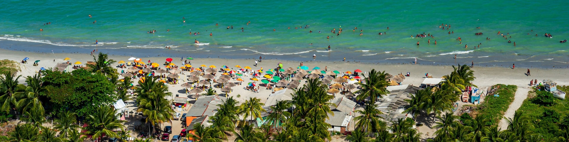 Maria Farinha beach, Olinda, near Recife, Pernambuco State, Brazil on November 15, 2012. Aerial view of the beach with colorful parasols and countless people on the beach.