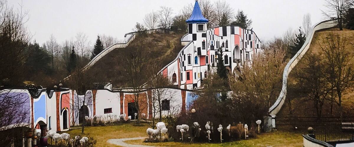 A colorful, whimsical village with a prominent blue-roofed tower and winding paths.