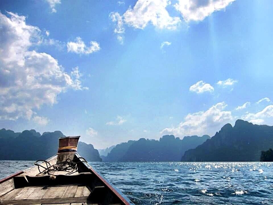 A boat on a calm sea with mountains in the background.