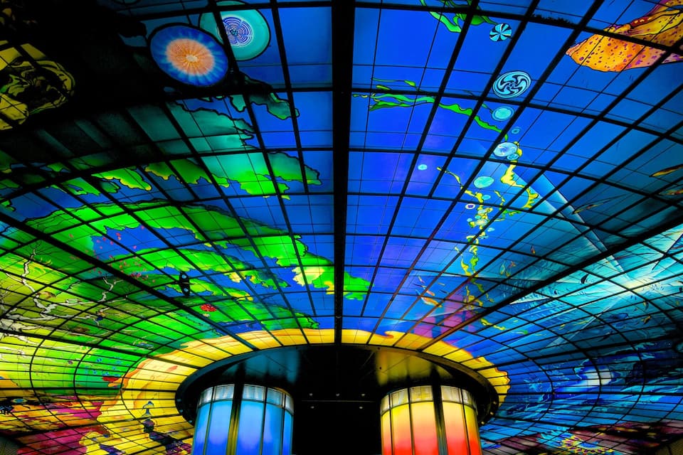A colorful stained glass ceiling with a grid pattern and various abstract designs.