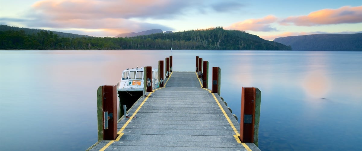 A pier extending into calm waters with a boat docked at the end.