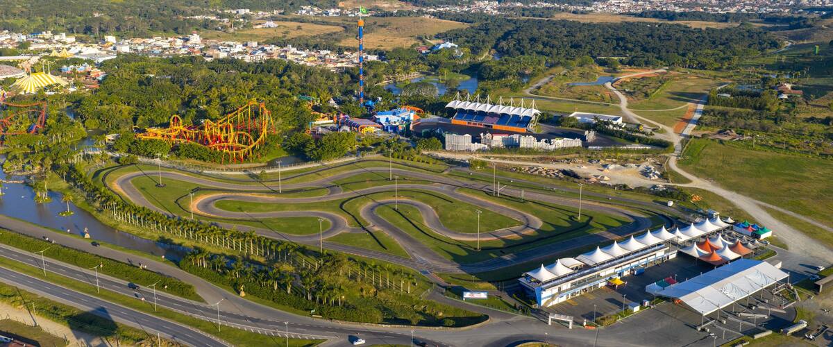 Drone view of Beto Carrero World kart track and amusement park with coastal city in the background.
