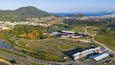Drone view of Beto Carrero World kart track and amusement park with coastal city in the background.