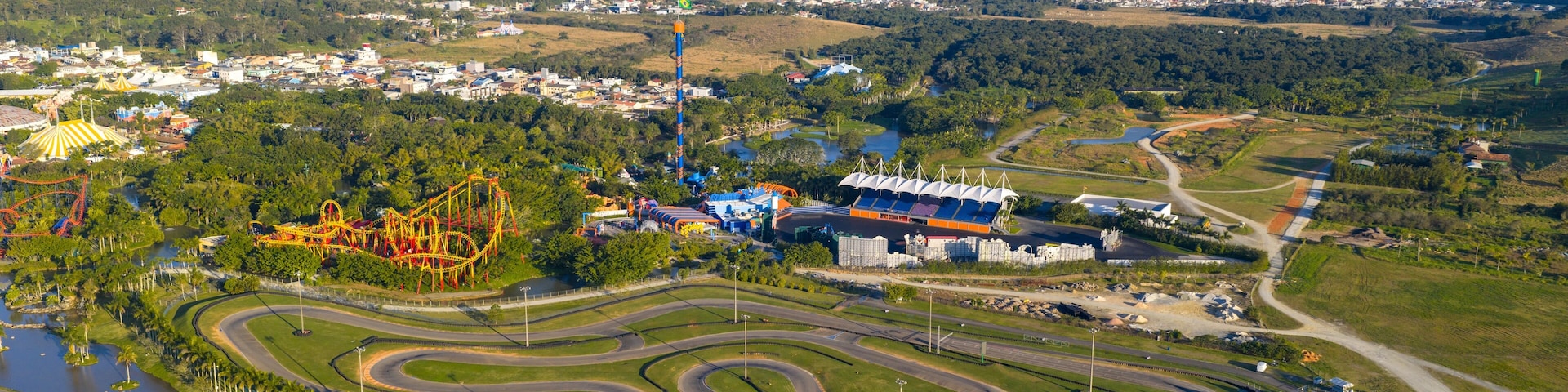 Drone view of Beto Carrero World kart track and amusement park with coastal city in the background.