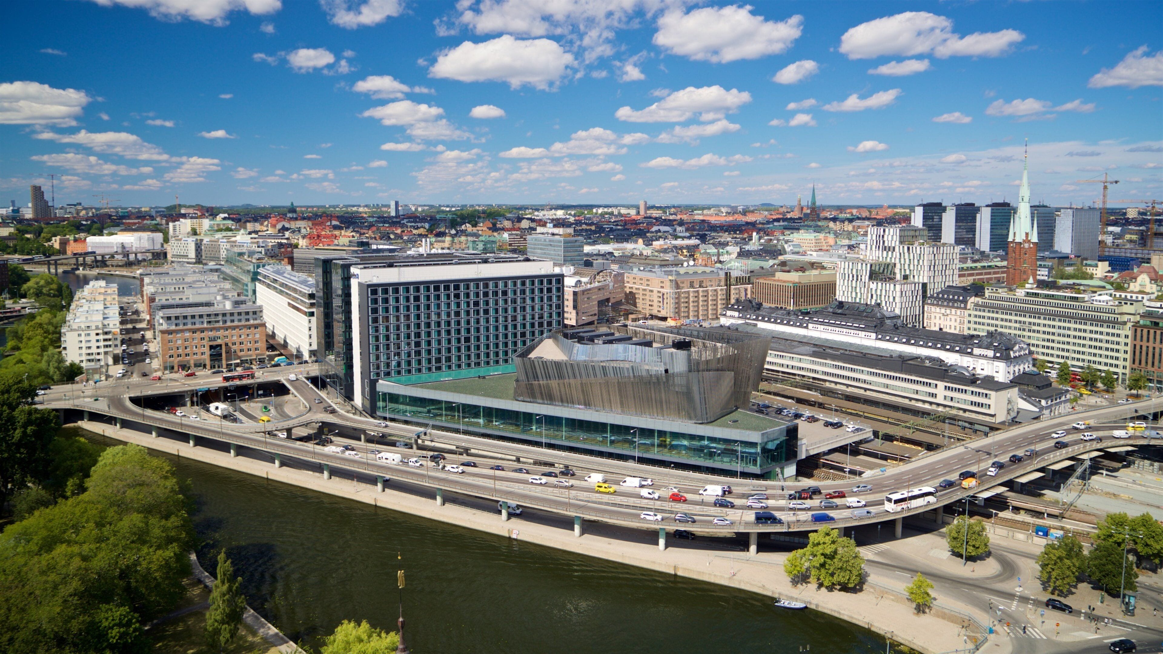 A cityscape with a river, modern buildings, and a prominent tower.