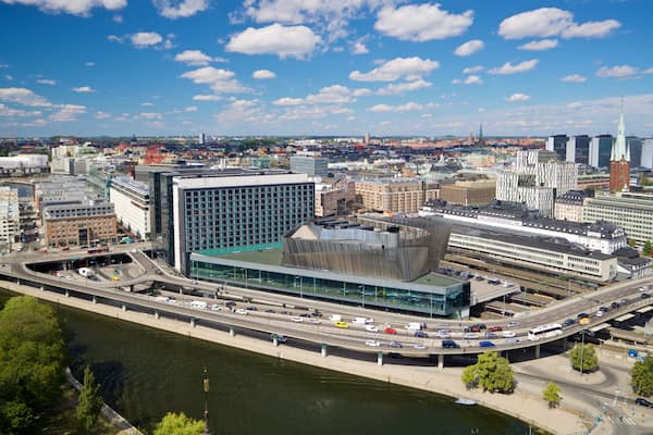 A cityscape with a river, modern buildings, and a prominent tower.