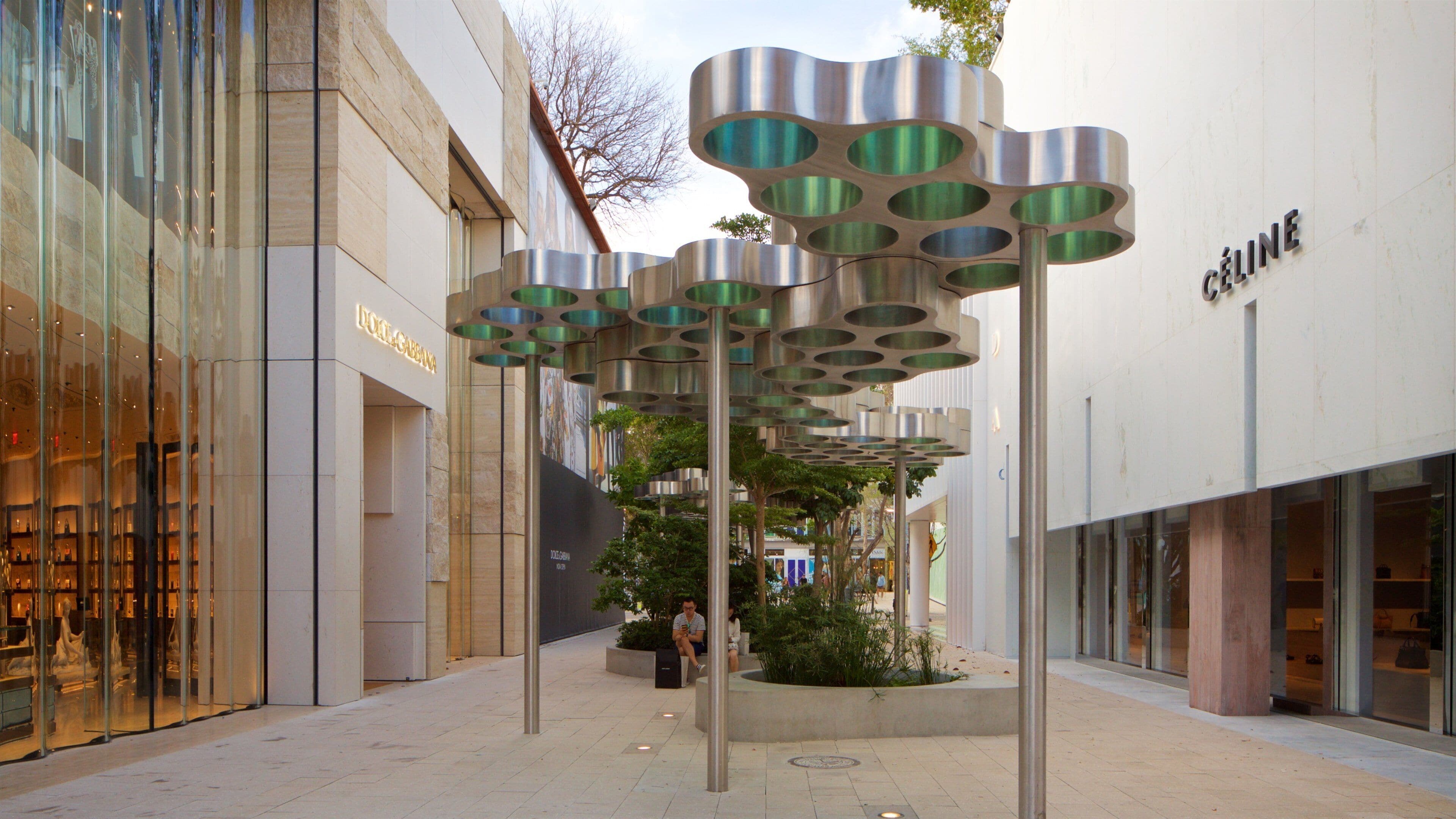 A shopping area with modern architecture, including a Dolce & Gabbana store and a Céline store.