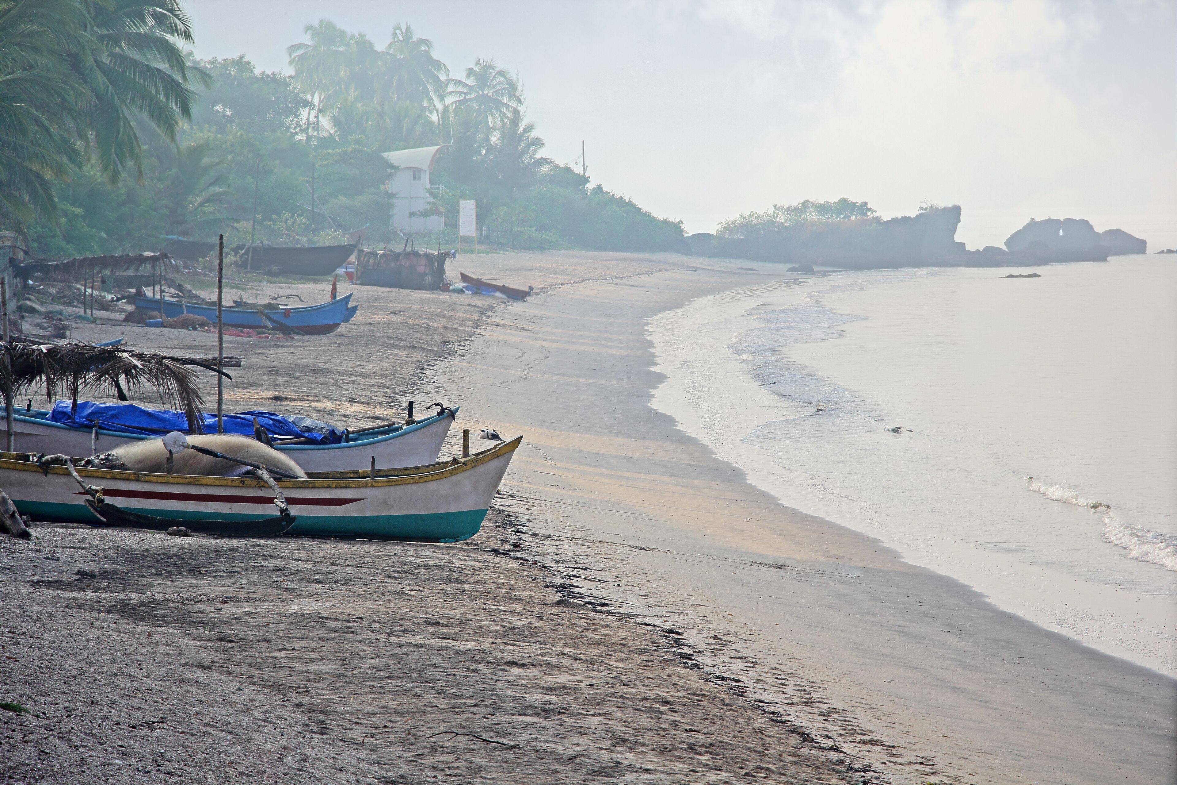 Morning scene of fishing boats resting on the beach at Siridao fishing village in Goa, India