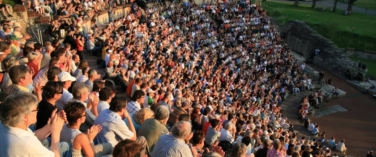 A large crowd of people seated in an outdoor amphitheater.