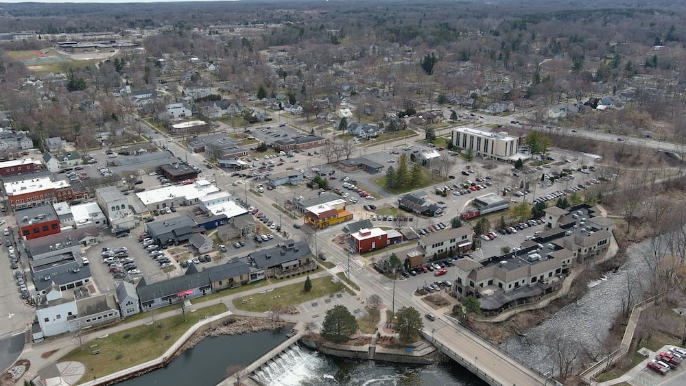 A town with a river, buildings, and a bridge.