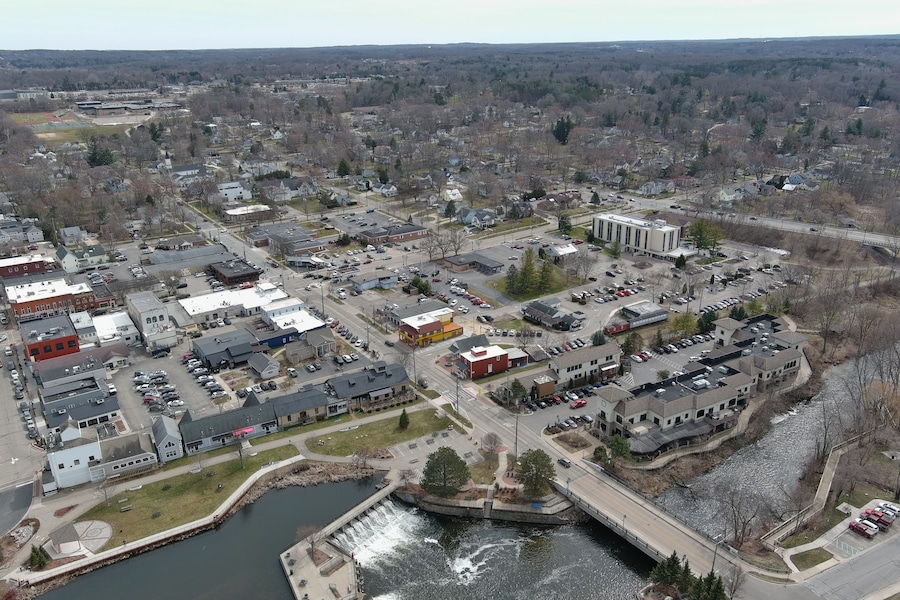 A town with a river, buildings, and a bridge.