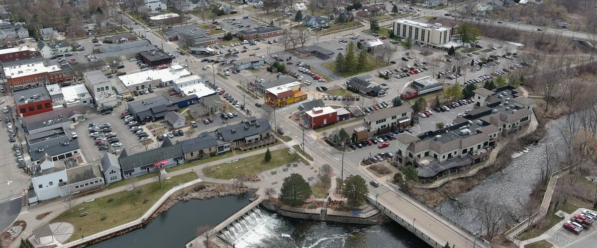 A town with a river, buildings, and a bridge.