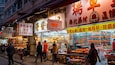 A bustling street market with various shops and stalls selling goods.