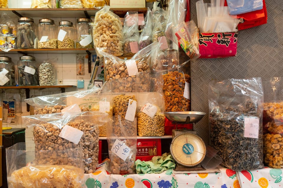 Diverse verpakte noten en gedroogde producten staan uitgestald in een winkel.