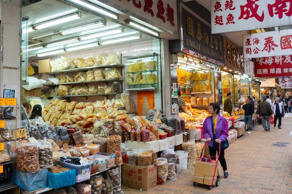 Ein belebter Markt mit verschiedenen Essensständen, die Trockenwaren und Snacks anbieten.