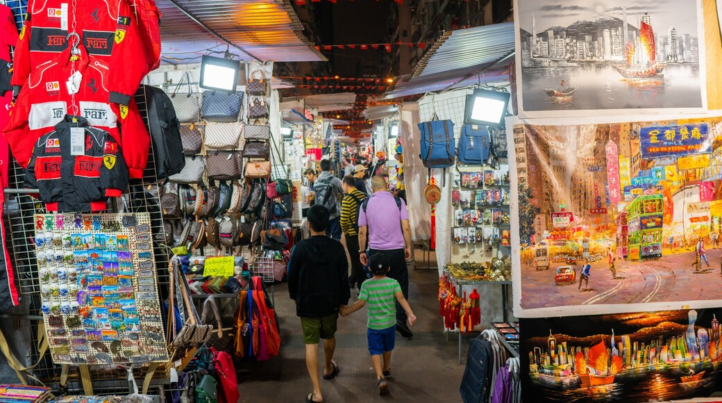 Temple Street Night Market showing night scenes and markets as well as a family