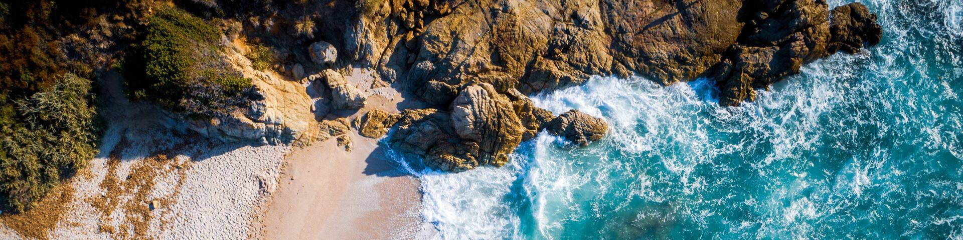 Aerial view of waves crashing on beach, Calvi, Corsica, France