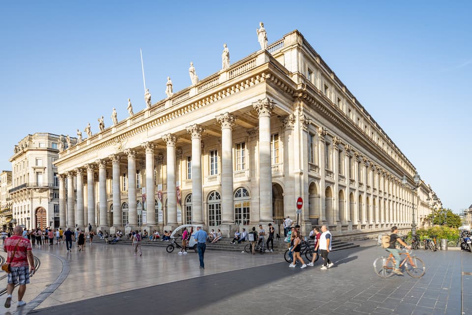 Un grand bâtiment historique orné de colonnes et de statues.