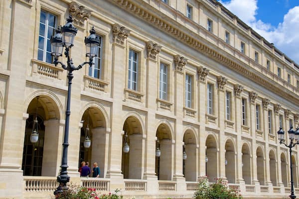Ein prächtiges historisches Gebäude mit klassischer Architektur, mit Säulen, Bögen und verzierten Straßenlaternen.