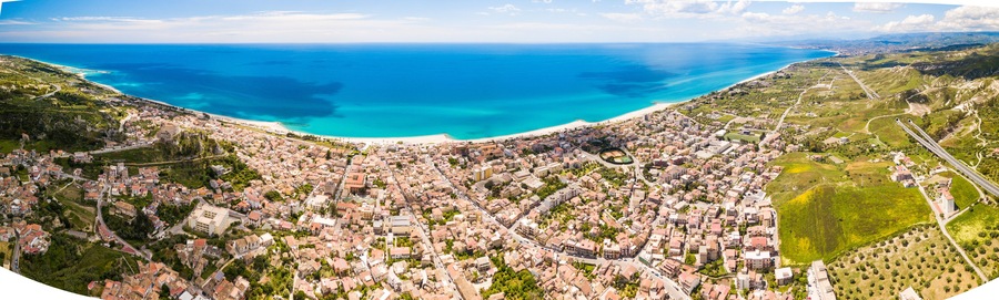 Città di Roccella Ionica in Calabria. Vista aerea del mare Mediterraneo, le case, la strada, la costa e il castello.