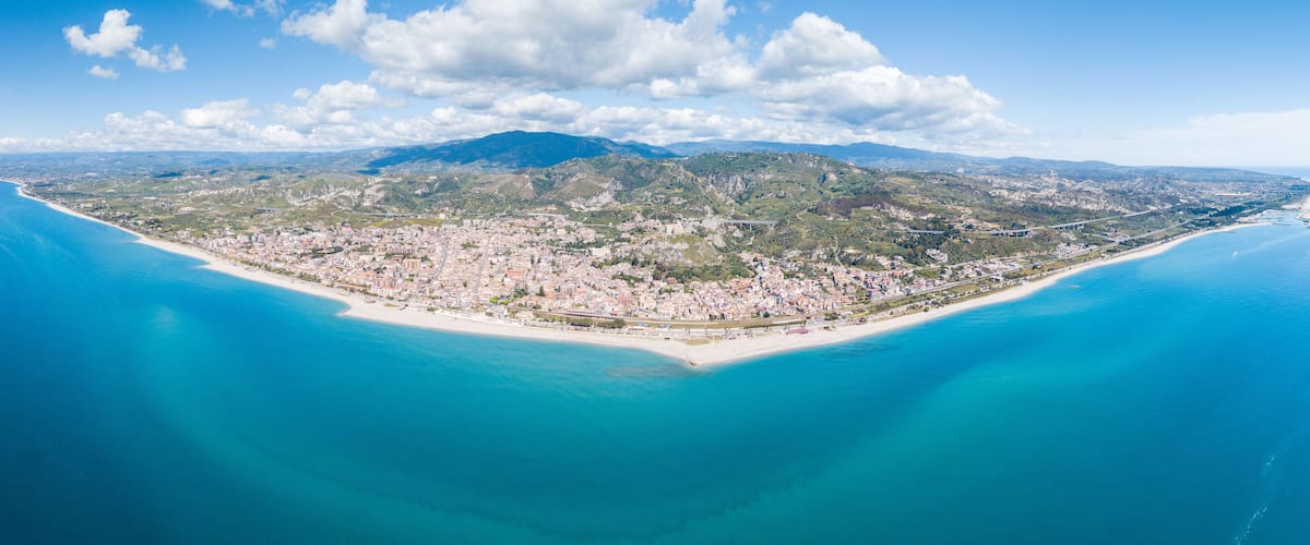 Roccella Ionica o Jonica, città in provincia di Reggio Calabria con affaccio sul mar Ionio Mediterraneo. Vista della costa sabbiosa, del castello e del porto dall'alto in Estate.