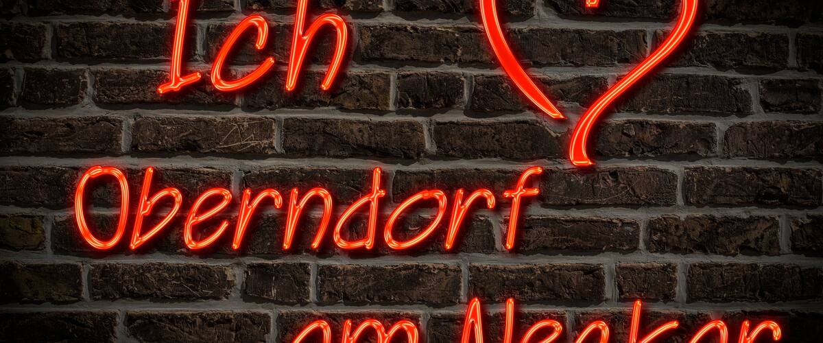 A neon sign with the text "Ich Oberndorf am Neckar" on a brick wall.