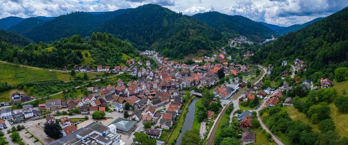A picturesque village nestled in a valley surrounded by lush green hills and mountains.