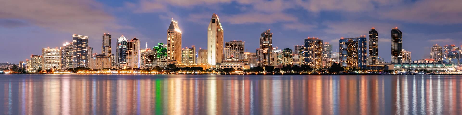 San Diego California skyline at night with reflections in water.