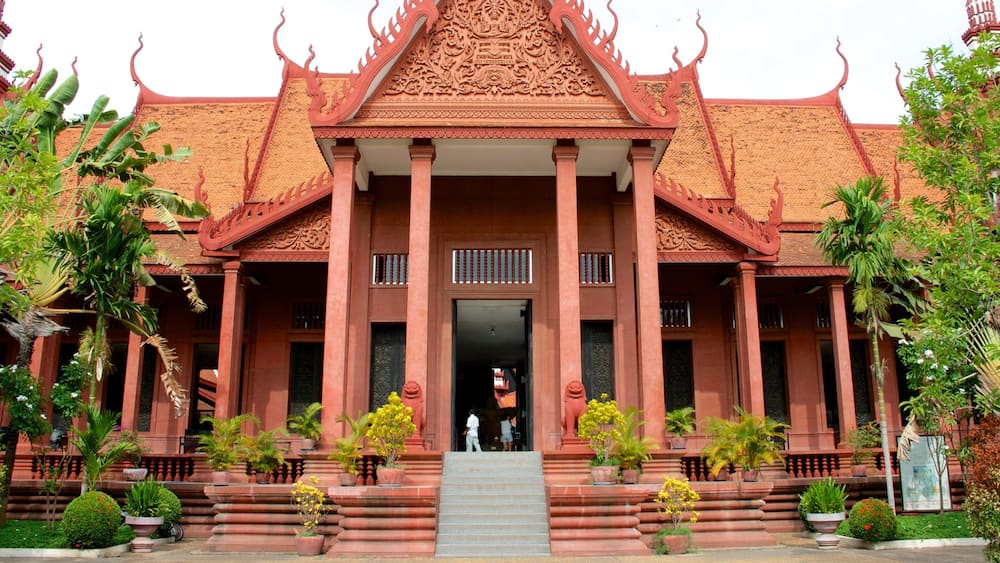 Et traditionelt thai tempel med udsøgt arkitektur, en central indgang og frodig beplantning omkring.