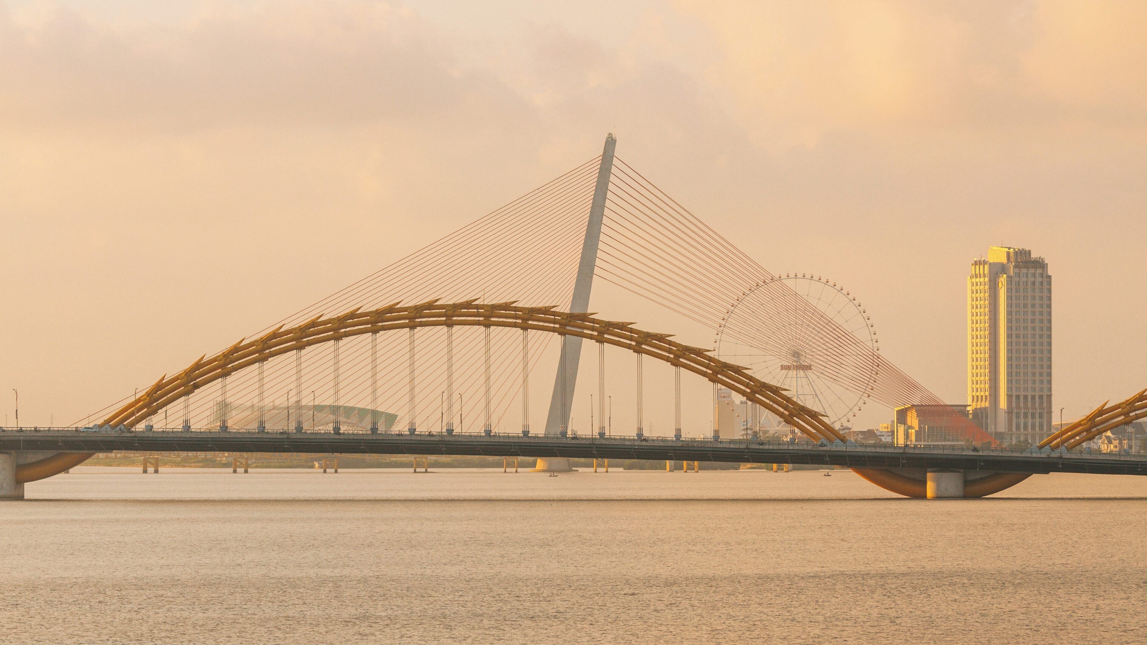 Golden sunrise over Han River in Son Tra, Da Nang showcasing the unique architecture of the dragon bridge and city skyline