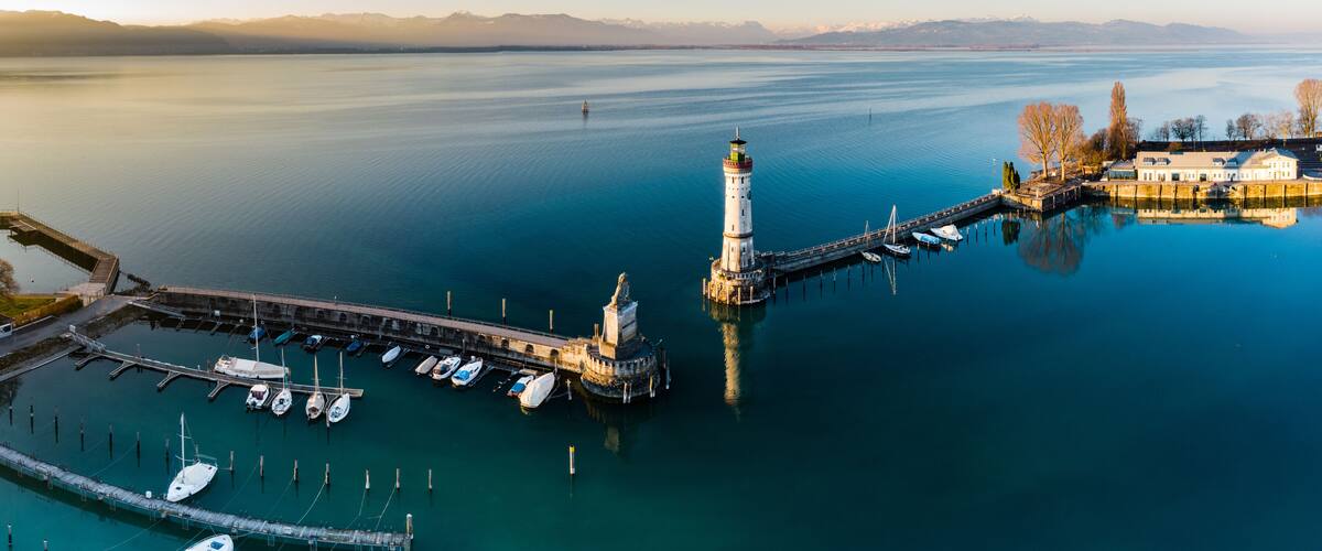A lighthouse, a pier, and a marina with boats.
