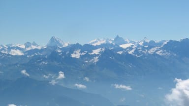 Uma cordilheira com picos nevados e um vale abaixo.