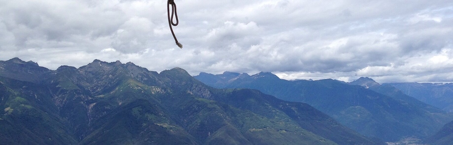 A bell tower with a panoramic view of mountains and a valley below.