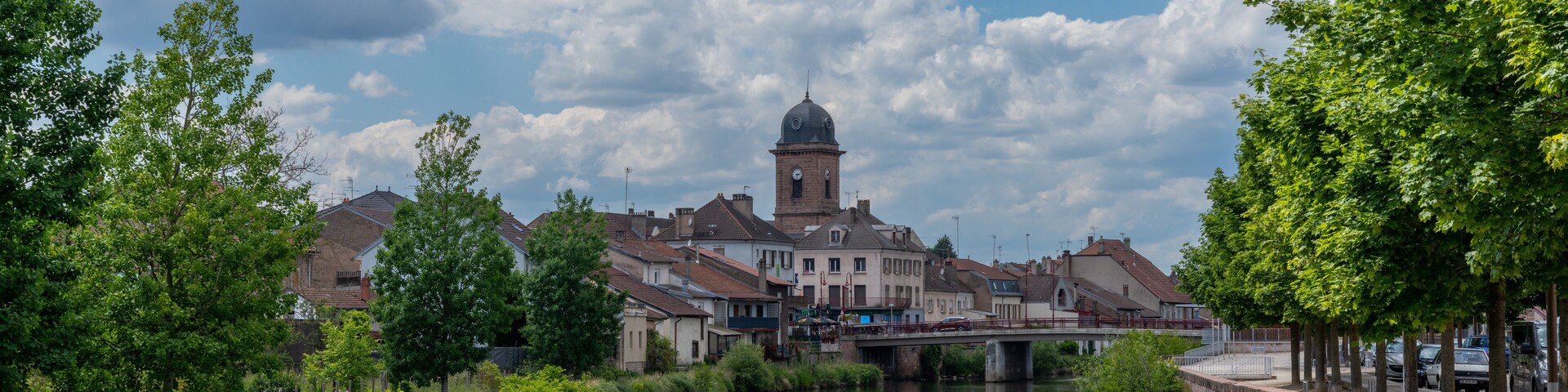 Un río con un puente, una torre y vegetación circundante.