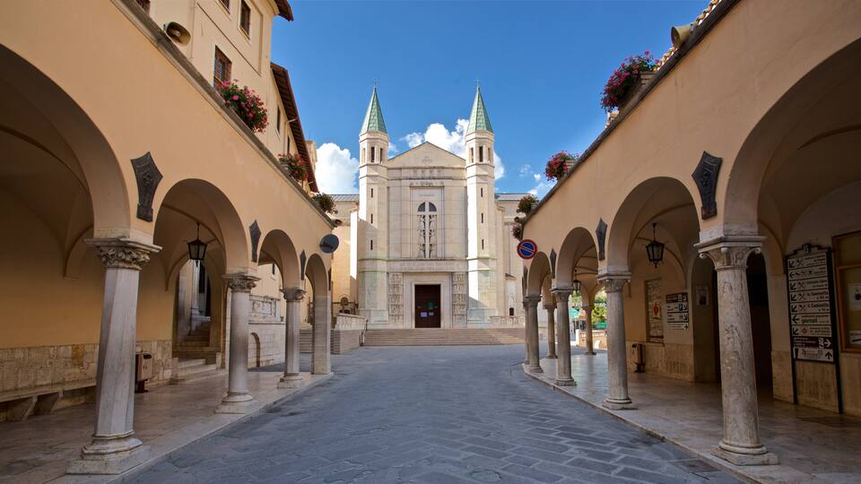 A historic church with twin spires and a central entrance, flanked by arched walkways and columns.