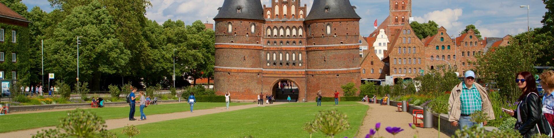 Museum Holstentor mit einem historische Architektur und Wildblumen sowie kleine Menschengruppe